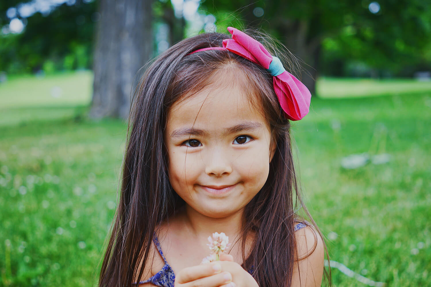Young girl holding small flower